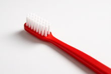 Load image into Gallery viewer, A red tooth brush

